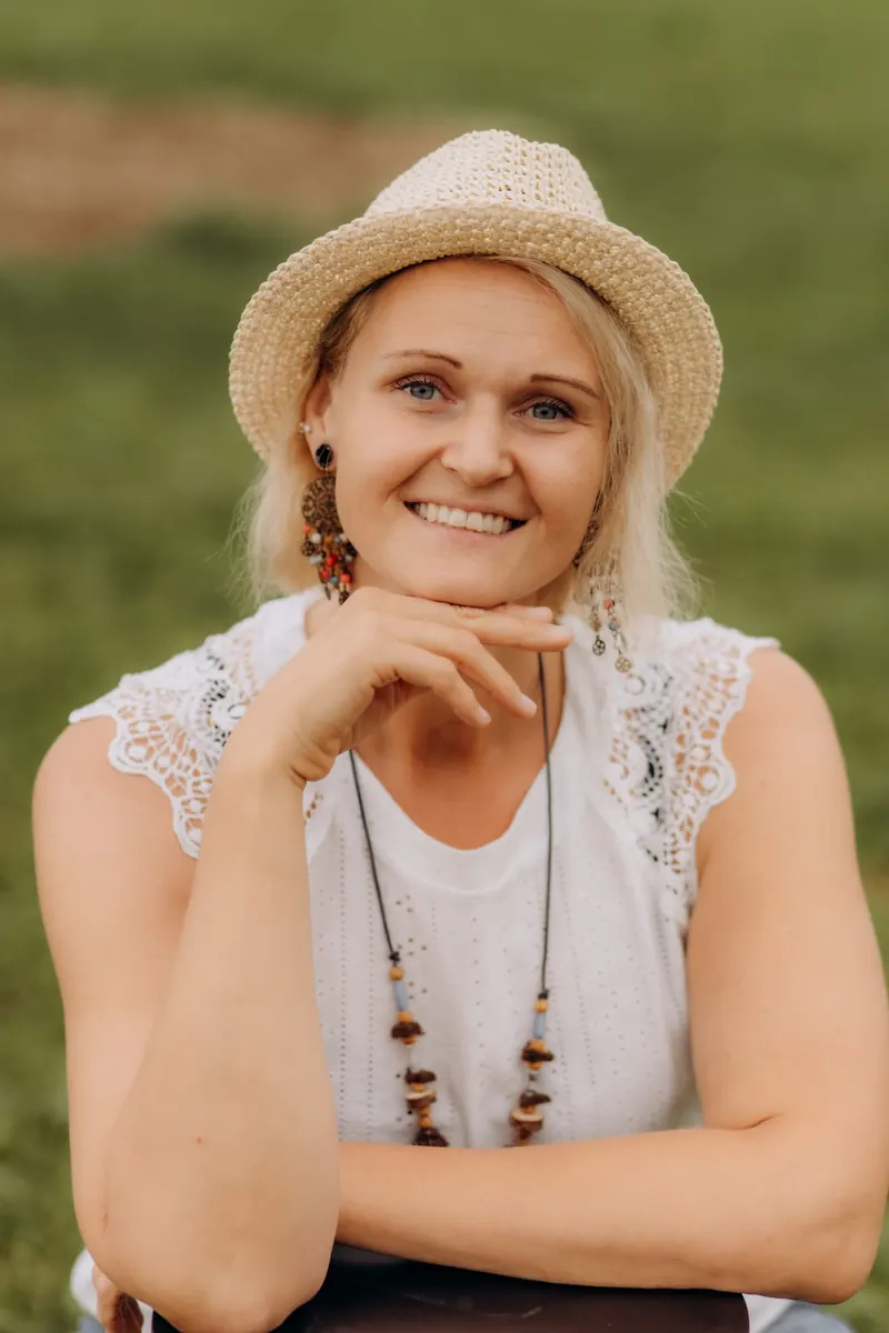 Porträt von Iris Pointinger mit Strohhut im Grünen